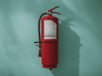 Photograph of a fire extinguisher mounted on a blue wall